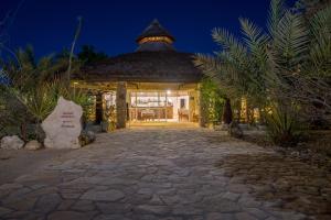 a stone pathway leading to a gazebo at night at Auberge de la Table in Toliara