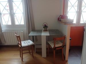 a small kitchen with a table and two chairs at Foudebassan in La Teste-de-Buch