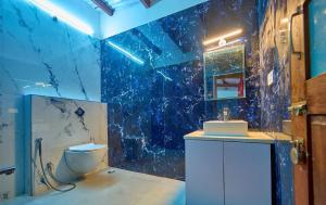 乌提Shivvs Heritage Resort Ooty的铺有蓝色瓷砖的浴室，配有马桶和水槽