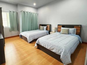 Dos camas en una habitación con suelo de madera. en BirdHostel Chiangrai, en Chiang Rai 7 fotos más