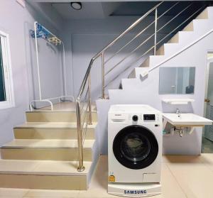 een wasmachine in een wasruimte met een trap bij Bird Hostel Chiangrai in Chiang Rai