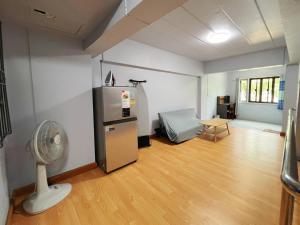 Habitación con nevera y ventilador. en BirdHostel Chiangrai, en Chiang Rai