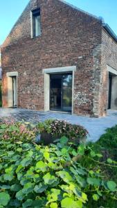 a brick building with a bunch of plants in front of it at Gîte du Papillon CALUTRE in Carvin