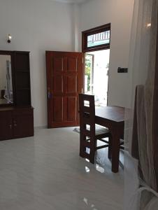 a dining room with a wooden table and a chair at Sun Terra Unawatuna in Unawatuna