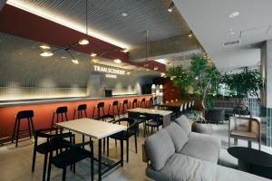 a restaurant with a bar with tables and chairs at TRANSCENDER HOTEL Yokohama in Yokohama