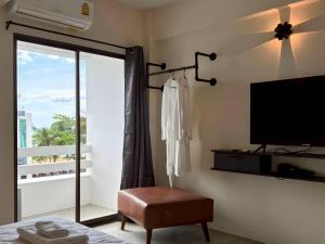 a bedroom with a flat screen tv and a window at VS Beach Front in Jomtien Beach