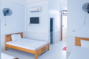 a small bedroom with a bed and a tv at Phương Phương 1 Hotel in Hà Tĩnh