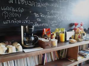 a chalkboard with a coffee maker on top of a table at Suneta Hostel Chiangkhan in Chiang Khan