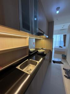 a kitchen with a sink and a counter at Pollux Habibie Deluxe 3 City View lt 28 by Superstay in Batam Center