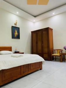 a bedroom with a bed and a wooden cabinet at Cali Hotel Tây Ninh in Tây Ninh