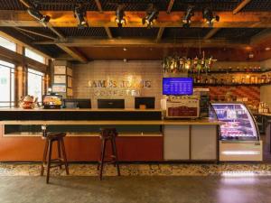 a bar in a restaurant with a counter at James Joyce Coffetel Xi'an Lingtong The Terracotta Army Huaqingchi University Town Metro Station in Xi'an