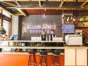 two people sitting at a bar with their laptops at James Joyce Coffetel Xi'an Lingtong The Terracotta Army Huaqingchi University Town Metro Station in Xi'an