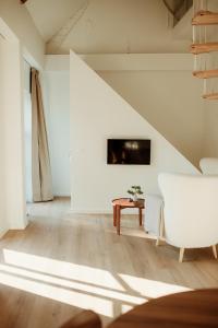 a living room with a white couch and a tv at Studio & Stay Loft in Ghent