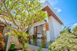 a house with a tree in front of it at Moringa Pandawa Guest House in Ungasan