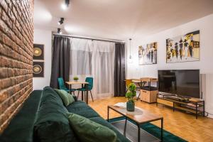 een woonkamer met een groene bank en een tv bij Clara in Rzeszów