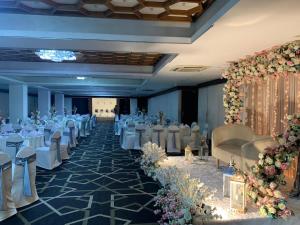 a banquet hall with white tables and chairs and flowers at Hotel Sapphire in Colombo