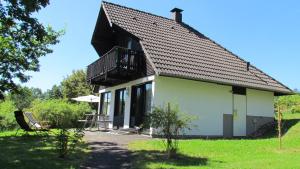 FrankenauにあるFrankenau 36の小さな白い家で、上にバルコニーが付いています。