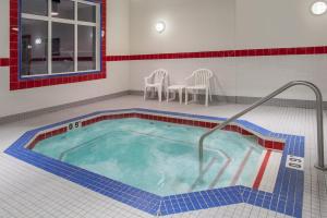 a bath room with a tub and a swimming pool at Ramada by Wyndham Brooks in Brooks