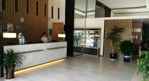 een vrouw die achter een balie in een lobby staat bij Jinjiang Inn Select Taizhou Jiangyan Coach Terminal in Magou