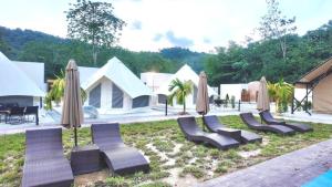 a group of chairs and umbrellas next to a pool at TheNyaman Place in Hulu Langat