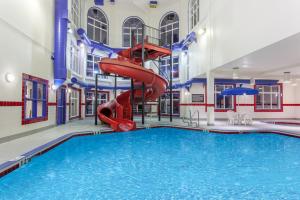 a pool with a red slide in a building at Ramada by Wyndham Brooks in Brooks