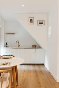 a kitchen with white cabinets and a staircase at Studio&Stay Room in Ghent
