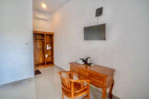 a room with a wooden desk with a phone on it at Moringa Pandawa Guest House in Ungasan