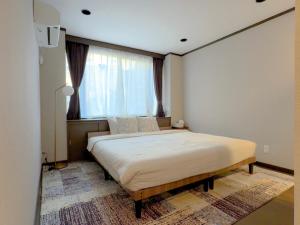 a bedroom with a large bed in front of a window at MANDO Hotel 101 in Tokyo