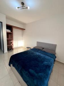 a bedroom with a large bed with a blue blanket at Beach Apartment in Ciudad Madero +9 photos