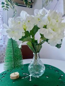 a glass vase with white flowers on a table at Buda Side Comfort in Budapest