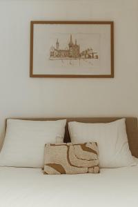 a picture above a bed with a picture on the wall at Studio&Stay Room in Ghent
