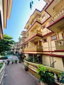 an apartment building with balconies and plants on a street at Candolim apartment in Candolim