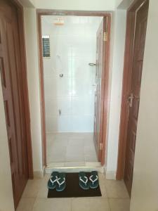 Un baño con ducha y una alfombrilla negra en el suelo. en Stylish 2BR with Wi-Fi and secure parking, en Kakamega