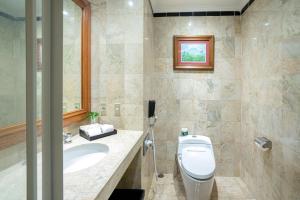 a bathroom with a toilet and a sink at Hotel Bumi Senyiur in Samarinda