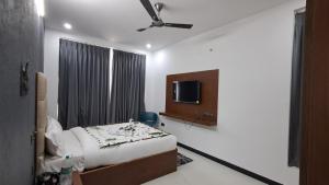 Un dormitorio con una cama y un televisor de pantalla plana. en Forest Abode, en Yercaud