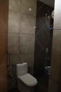 Un pequeño baño con inodoro y ducha. en Forest Abode, en Yercaud