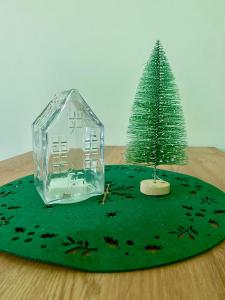 a miniature christmas tree and a house on a green rug at Buda Side Comfort in Budapest