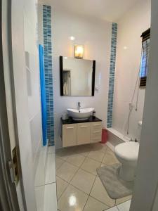 a bathroom with a sink and a toilet and a mirror at Grand Bay 4Bed Triplex Villa with Community Pool in Grand Baie