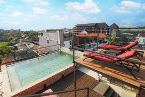 Un balcón con piscina en lo alto de un edificio. en Sky Suites, en Seminyak