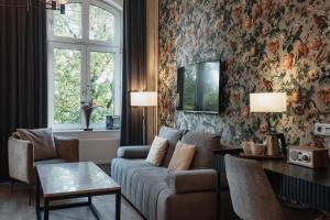 una sala de estar con un sofá y una mesa en Home Hotel Norre Park, en Halmstad