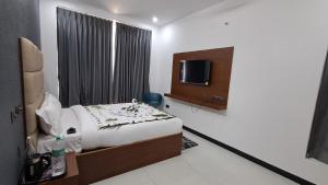 a hotel room with a bed and a tv at Forest Abode in Yercaud
