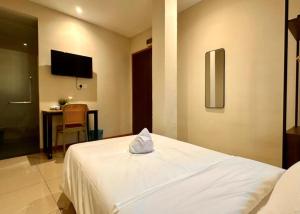 a hotel room with a white bed and a table at Swing & Pillows - Chow Kit Road, Kuala Lumpur in Kuala Lumpur