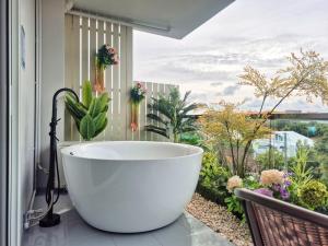 a bath tub sitting in front of a window with a view at HT9 Hotel in Jomtien Beach +204 photos
