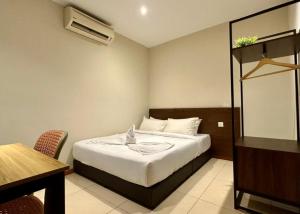a bedroom with a bed and a table and a desk at Swing & Pillows - Chow Kit Road, Kuala Lumpur in Kuala Lumpur