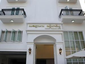 a white building with two balconies and a door at Reasmey Cheanich Hotel in Kampong Cham