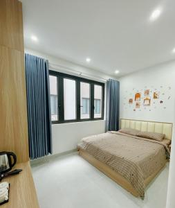 ein Schlafzimmer mit einem Bett und einigen Fenstern in der Unterkunft Creamy home - Homestay Vinhomes Ocean Park 3 in Ðình Loan