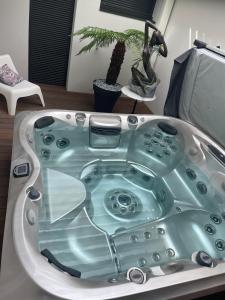 a bath tub in a living room with a plant at cocoon romantique avec jacuzzi proche plage in Saint-Gildas-de-Rhuys