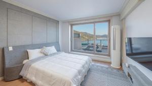 巨济Maremonte Pension的一间卧室，配有一张大床和一扇大窗户。