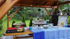 a table with a blue table cloth and a fireplace at Willa Gracja in Wisła