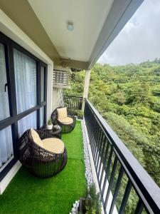 a balcony with two wicker chairs and a table at The Banyan Rest in Balibaguhan